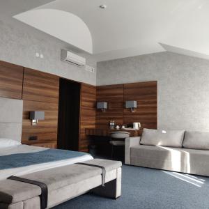 ein Schlafzimmer mit einem Bett, einem Sofa und einem Waschbecken in der Unterkunft Hotel Zefir in Drohobytsch