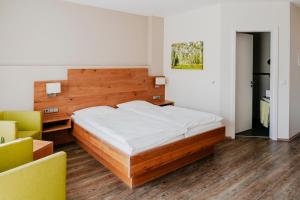 ein Schlafzimmer mit einem großen Bett und einem gelben Stuhl in der Unterkunft Hotel Birkenhof in Heidelberg