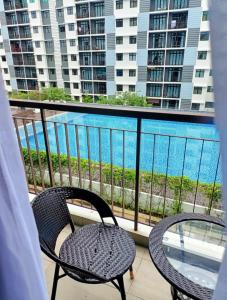 balcón con 2 sillas y vistas al agua en Pangsapuri Desaru Utama Homestay en Bandar Penawar