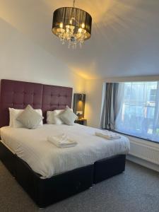 a bedroom with a large bed with a large window at Kings Hotel in Newmarket
