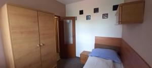 Dormitorio pequeño con cama y armario en Expres Atack Penzion, en Brno
