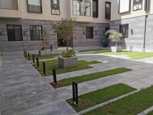 a courtyard of a building with trees and plants at wafms Apartments in Riyadh