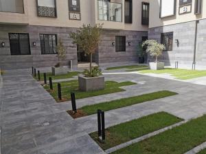 a courtyard of a building with trees and plants at شقة راقية بثلاث غرف نوم ودخول ذاتي in Riyadh