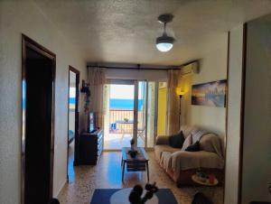 a living room with a couch and a view of the ocean at Sea view 3-bedroom flat in Puerto de Mazarron in Puerto de Mazarrón