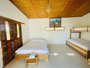 a bedroom with two beds and a wooden ceiling at Ecohotel Kocoluu in San Bernardo del Viento