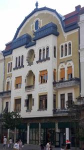 un gran edificio blanco con gente caminando delante de él en Neuhausz Residenz Ultra-Central Apartment, en Timisoara