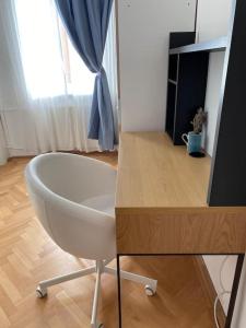 a white chair sitting in a room with a tv at Neuhausz Residenz Ultra-Central Apartment in Timişoara