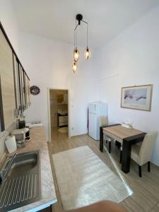 a kitchen and dining room with a table and a sink at Neuhausz Residenz Ultra-Central Apartment in Timişoara