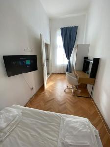 a bedroom with a bed and a desk with a computer at Neuhausz Residenz Ultra-Central Apartment in Timişoara