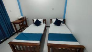 馬納爾的住宿－Victory's Gardens，蓝色和白色的客房内的两张床