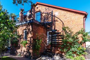 ein Backsteingebäude mit einer Wendeltreppe darauf in der Unterkunft Gostynin Garden Apartment III in Gostynin