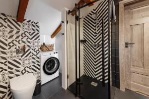 ein Badezimmer mit einer Waschmaschine, einer Waschmaschine und einem Trockner in der Unterkunft Gostynin Garden Apartment III in Gostynin