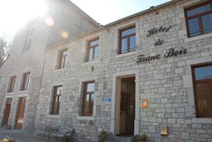 un edificio de piedra con un cartel en la parte delantera en Hotel De Franc Bois en Chimay