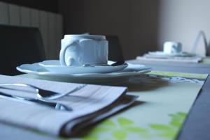 a table with plates and a coffee cup on it at Hotel De Franc Bois 