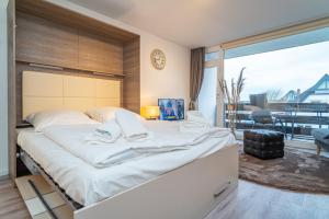 a large white bed in a room with a large window at Bismarck-Koje in Westerland