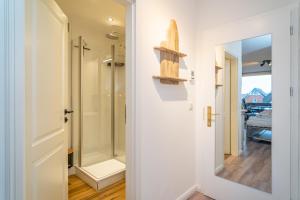 a bathroom with a walk in shower next to a door at Bismarck-Koje in Westerland +15 photos