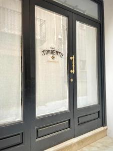 a black door with a sign on it at Cal Torrentó Apartaments in Balaguer