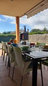 a table with chairs and a stove on a patio at Villa Mediterránea con Cinco Dormitorios y Piscina in Calonge