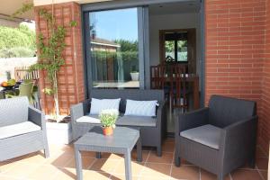 a patio with two chairs and a table on a patio at Villa Mediterránea con Cinco Dormitorios y Piscina in Calonge