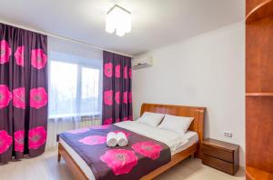 ein Schlafzimmer mit einem Bett mit rosa Blumen drauf in der Unterkunft Central Apartments Palats Sportu Area in Kiew