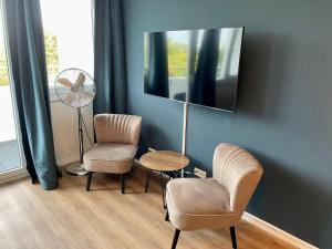 a living room with two chairs and a fan at River Main I Taunus View I Workplace I Kitchen in Offenbach