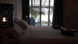 a bedroom with a large white bed with a window at PP Blue Sky Resort-SHA Plus in Phi Phi Islands