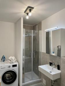 a bathroom with a shower and a washing machine at River Main I Taunus View I Workplace I Kitchen in Offenbach