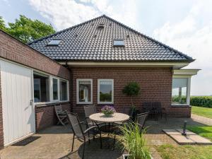 a brick house with a table and chairs at Holiday home with wide views and garden in Balkbrug