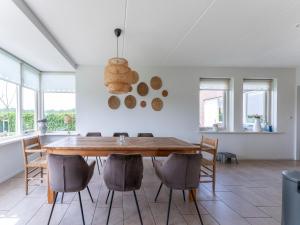 comedor con mesa de madera y sillas en Holiday home with wide views and garden en Balkbrug
