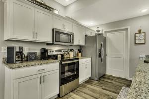 a kitchen with white cabinets and a stainless steel refrigerator at Sunset Bunker condo in Branson West +38 photos