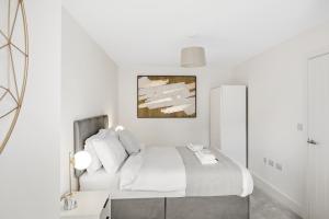 a white bedroom with a bed and a mirror at Tailored Stays - Water Street Apartments in Cambridge