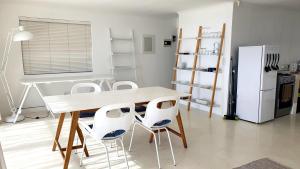 a kitchen with a table and two white chairs at Stunning Simonstown Apartment in Simonʼs Town