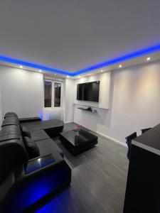 a living room with a black couch and a tv at MeandYou Hammametspa in Colmar