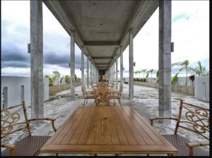 einen Holztisch und Stühle auf einer Veranda mit Strand in der Unterkunft LOT 8 CONDOMINIUM 1BEDROOM MABOLO CEBU in Carreta
