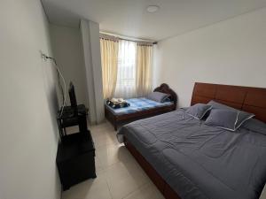 ein Schlafzimmer mit einem Bett und einem TV in der Unterkunft Hotel Playa Blanca in Tota