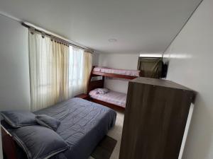 ein kleines Schlafzimmer mit 2 Etagenbetten und einem Fenster in der Unterkunft Hotel Playa Blanca in Tota