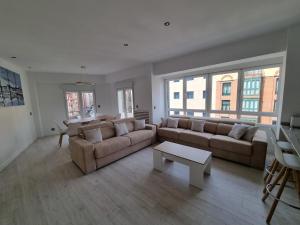 Sala de estar con 2 sofás y mesa de centro en 131A - Espectacular apartamento 8 personas Puerto, en Gijón
