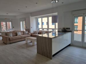 cocina y sala de estar con sofá y mesa en 131A - Espectacular apartamento 8 personas Puerto, en Gijón