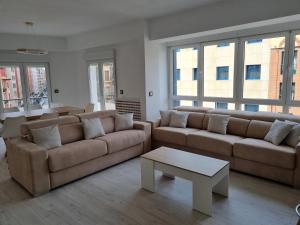 Sala de estar con 2 sofás y mesa de centro en 131A - Espectacular apartamento 8 personas Puerto, en Gijón