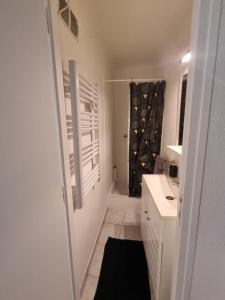 a bathroom with a sink and a shower with a window at Appartement coquet Le Boulou in Le Boulou