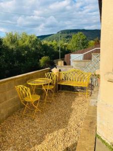 a patio with a table and chairs on a balcony at Goldcroft in Abertillery