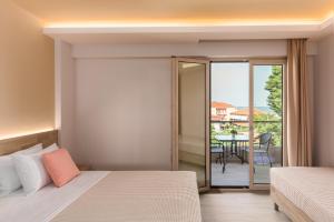 a bedroom with a bed and a balcony with a table at Makris Luxury Rooms in Leptokarya