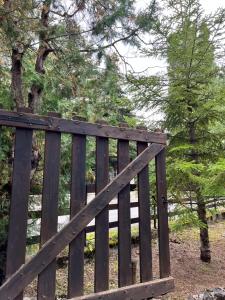a wooden fence with trees in the background at Porta degli Elfi-Residence San Vito in Pescocostanzo