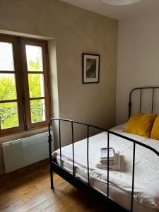 a bedroom with a bed and two windows at Chambres d'hôtes Place Balanant in Buzançais