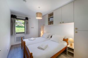 een slaapkamer met 2 bedden en een raam bij Les 4 Elements - Apt A11 - BO Immobilier in Châtel