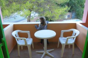 a little girl sitting at a table and two chairs at Chalikias Rooms in Asprogerakata