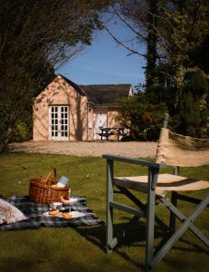 a picnic blanket on the grass in front of a cottage at Cottage at the Alms - Dog Friendly! in Strangford