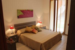 een slaapkamer met een bed met 2 lampen en een schilderij bij Casa di Chiara in Peschiera del Garda