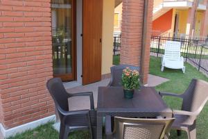 een patio met een tafel en stoelen met een plant erop bij Casa di Chiara in Peschiera del Garda