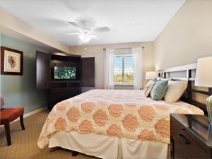 a bedroom with a large bed and a television at Yacht Club Villas #2-405 condo in Myrtle Beach